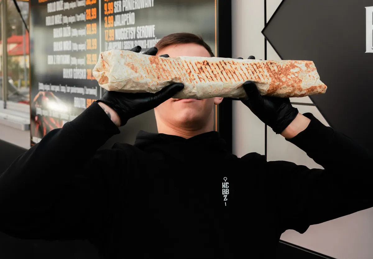 BRUTAL z Kebbz, kebab na dwóch lawaszach trzymany oburącz na wysokości twarzy